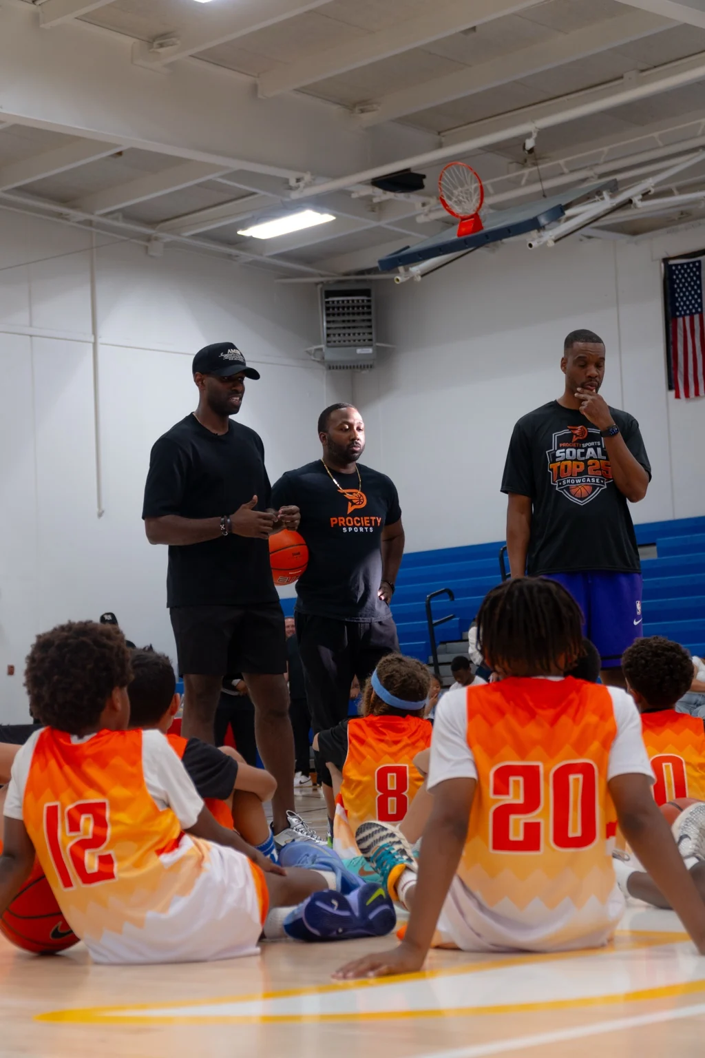 Prociety coaches speaking with players during a showcase huddle